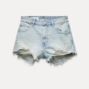 Ljusa jeansshorts med slitningar - Säljer ett par ljusa jeansshorts i bra skick. De har en cool, sliten look med fransiga kanter och slitningar på framsidan.  De är högmidjade och har klassiska fem fickor samt knapp och dragkedja framtill. Endast använd fåtal gånger. Ordinarie pris:329 💛