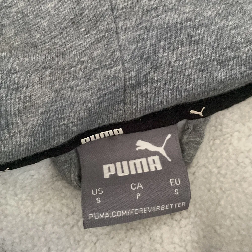 Säljer en grå hoodie från Puma i mycket bra skick. Den har en dragkedja framtill och en klassisk huva. Perfekt för höst och vinter, och den är supermjuk och bekväm. Passar både för träning och vardagsbruk. 🐾. Tröjor & Koftor.