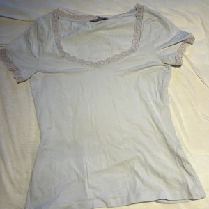 Vit topp med spetsdetaljer från Anna Field - Säljer en söt vit topp från Anna Field i mycket bra skick. Den har korta ärmar och fina spetsdetaljer runt halsringningen och ärmsluten. Perfekt för vår och sommar! 🌸