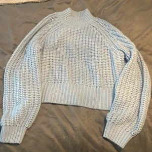 Ljusblå stickad tröja från Noisy May - Superfin ljusblå stickad tröja från Noisy May. Den har en mysig polokrage och är perfekt för kyliga dagar. Tröjan har långa ärmar med ribbade muddar. Perfekt för både höst och vinter! 