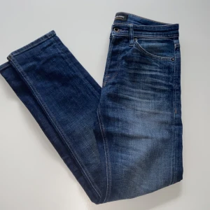 Blå jeans från Jack & Jones - Säljer ett par snygga blå jeans från Jack & Jones i modellen Tapered/Mike. De har en klassisk femficksdesign och är i bra skick. Perfekta för vardag. 10/10 skick. Bara att fråga om fler bilder eller mått 📏✌🏻