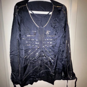 Mörk indigo blus med stjärndetaljer från Non Sense - Säljer en snygg mörk indigo blus med coola stjärndetaljer och nitar. Blusen har en v-ringad design och långa ärmar. Perfekt för en kväll ute eller en fest. Den är i mycket bra skick och redo att bäras av någon som vill sticka ut,tillkommer extra nitar och knappar denna tröja är aldrig använd så detta är rena kapet ny pris 2550:-(Mörk Navy)