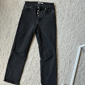 Svarta jeans från NA-KD - Säljer ett par snygga svarta jeans från NA-KD i storlek 38. De har en klassisk femficksdesign och knappar framtill. Perfekta för både vardag och fest!