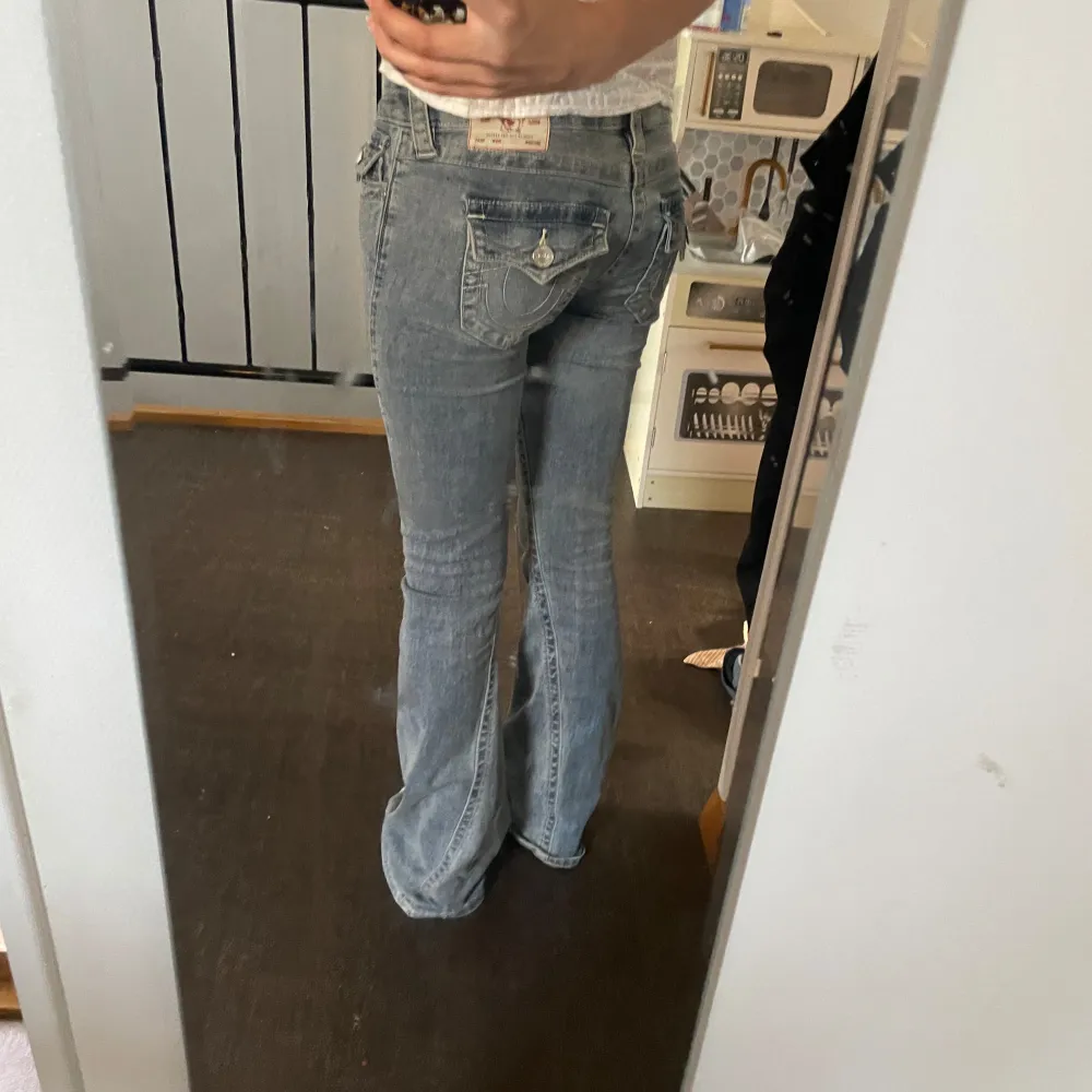 Säljer ett par snygga blå bootcut jeans i en klassisk stil. De är lågmidjade och har en lätt slitning framtill som ger en cool look. Perfekta för både vardag och fest!. Jeans & Byxor.