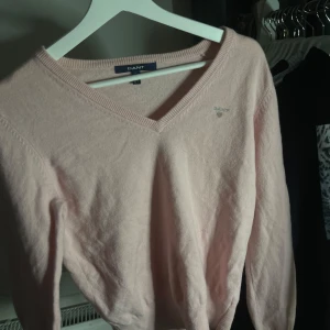 Stickad Gant tröja - En ljusrosa stickad Gant tröja med V-ringning. Den är precis som nu och använd ett fåtal gånger. Storleken är L men skulle mer säga att den passar XS-M beroende på vilken passform man vill ha. Kom gärna med prisförslag!💕