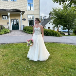 Balklänning - Jätte fin champagne färgad klänning passar alla storlekar då man spänner åt med snöre i ryggen använd en gång och köpt begagnad underkjol och skydd påse medföljer kom privat för frågor! Men det här är bilderna jag har.🩷😊