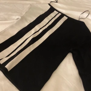 Svart och vit randig tröja - De populära tröjorna. Snygg svart och vit randig tröja med smala axelband. Perfekt för en stilren look. Tröja har en bra passform och är gjord i ett mjukt material som känns skönt mot huden. Använd 2 gånger.