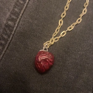 Halsband med röd hänge - Unikt halsband som jag själv har gjort med ett hänge som ser ut som ett hjärta. Kedjan är guldig och har en robust länkdesign. Perfekt för att ge din outfit en edgy touch. Passar både till vardags och fest! Hör av er vid intresse, pris går att diskutera:)
