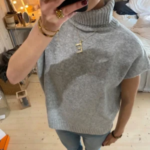 Grå ärmlös polotröja - Säljer en supermysig grå ärmlös polotröja. Perfekt för lager-på-lager under hösten eller vintern. Den har en hög polokrage och är i ett mjukt material som känns skönt mot huden. ⭐️💕