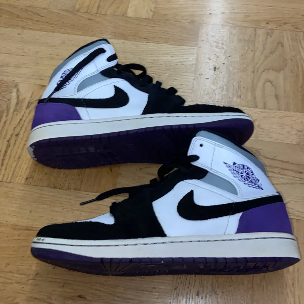 Säljer ett par snygga Nike Air Jordans i svart, vit och lila. Skorna har en klassisk design med snörning och är i mycket bra skick. Perfekta för både vardag och fest! 🖤💜. Skor.