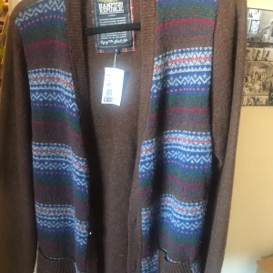 Brun kofta från Hampton Republic - Säljer en snygg brun vintage kofta från Hampton Republic i storlek M. Den har ett färgglatt mönster i blått, rött och vitt på framsidan. Koftan är perfekt för höst och vinter med sina långa ärmar och ribbade muddar. Köpte den i en second hand, men använde den aldrig.