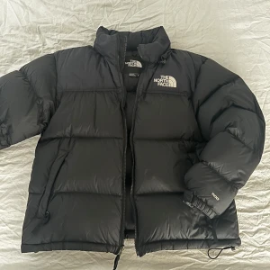 1996 Retro Nuptse Jacka The north face - Säljer en svart pufferjacka från The North Face i storlek L. Jackan är i mycket bra skick. Skick 9/10. Nypris: 3899kr 