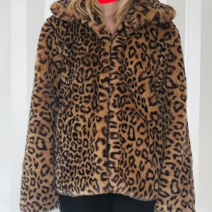 Leopardmönstrad pälsjacka - Säljer en supercool leopardmönstrad pälsjacka i syntetmaterial. Den är perfekt för höst och vinter och har en mysig, oversized passform. Jackan har långa ärmar och en hög krage som håller dig varm. Perfekt för att sticka ut på festen eller bara känna sig extra glamorös i vardagen! 🐆✨
