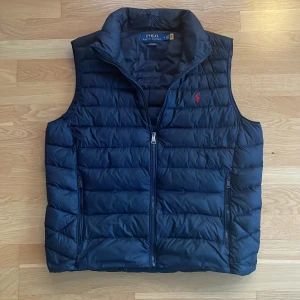 Polo Ralph Lauren Väst - Tjena, säljer nu min mörkblåa Polo Ralph Laruren väst i storlek M. Västen är i mycket bra skick, 9/10. Nypris är 3199kr mitt pris är 1399kr. Om du har några frågor är det bara att fråga😄