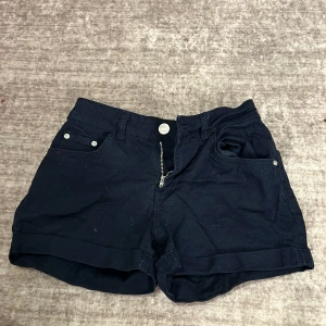 Svarta shorts från Terranova - Säljer ett par svarta shorts från Terranova i bra skick. De har en klassisk design med knappar och dragkedja framtill samt fickor på sidorna. Perfekta för sommardagar eller en avslappnad utflykt. Passar till det mesta i garderoben!