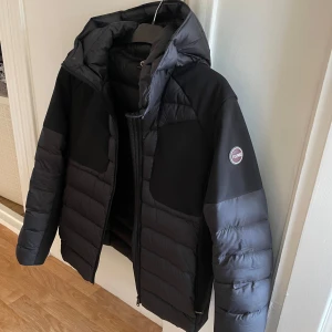 Svart pufferjacka från Colmar - Säljer en snygg svart pufferjacka från Colmar. Den är perfekt för kalla dagar med sin vadderade design och har en praktisk dragkedja framtill. Jackan har en stilren look med en liten logga på ärmen. Perfekt för både vardag och vinteräventyr! 🖤ny pris 5000kr mitt pris 2300kr billigare vid snabb affär! Använder förra vintern ca 3 månader.