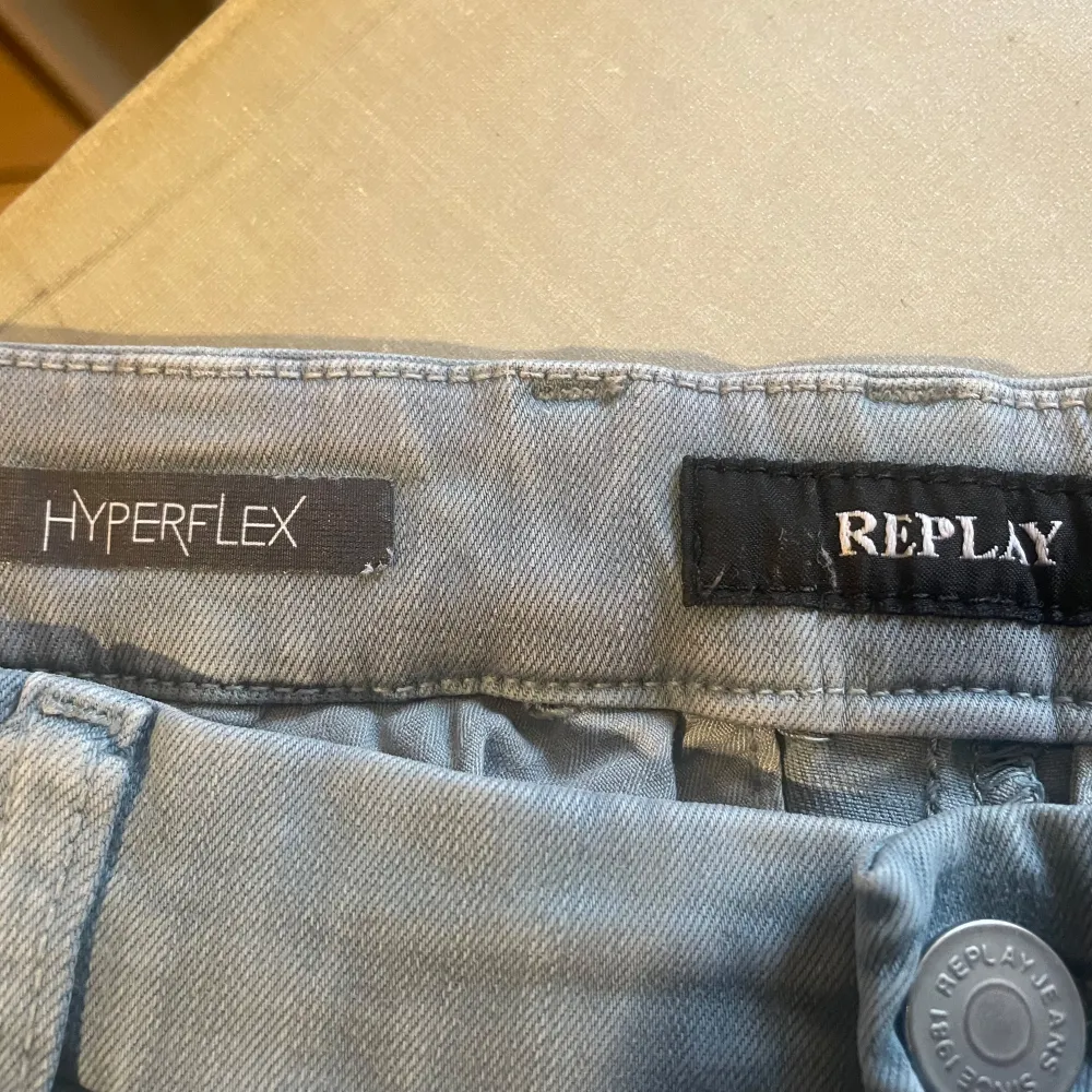 Säljer ett par snygga blå byxor från Replay i modellen Hyperflex. De har en normal passform och är perfekta för både vardag och fest. Byxorna är i mycket bra skick och har en stilren design med dragkedja och knappar. Perfekta för dig som vill ha både stil och komfort!. Jeans & Byxor.