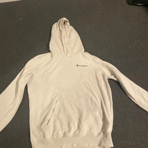 Vit hoodie från Champion - Säljer en vit hoodie från Champion i bra skick. Hoodien saknar snören men annars inget fel 