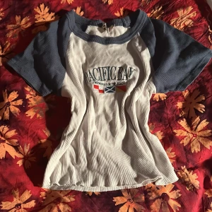 Vit och blå t-shirt från new yourker  - Säljer en snygg vit och blå t-shirt från new yourker. Den har korta ärmar och ett coolt tryck på framsidan. Perfekt för en avslappnad stil. Passar bra till jeans eller shorts!