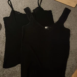 Svarta linnen med spetsdetaljer - Två snygga svarta linnen med spetsdetaljer vid axelbanden. Perfekta för både vardag och fest. Ena är från lager 157 och andra från mywear använda typ 3 gånger 