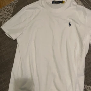 Vit t-shirt från Polo Ralph Lauren - Säljer en klassisk vit t-shirt från Polo Ralph Lauren i storlek M. T-shirten är aldrig använt, har kvar sin paket lukt! Anledningen till salu är att jag har på mig str XS och fick fel storlek som present.