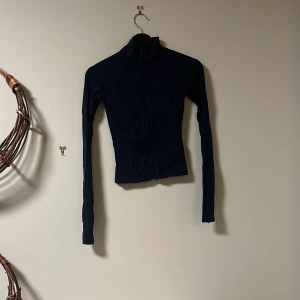 Mörkblå tröja från Gina Tricot - Säljer en mörkblå tröja från Gina Tricot i storlek XXS. Tröjan har en dragkedja framtill och långa ärmar. Perfekt för höst och vår! Den är i bra skick med en liten fläck på ärmen. Passar både till vardags och lite mer uppklädda tillfällen. Skönt mjukt material som är super skönt mot kroppen💞