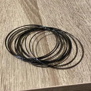 Svarta glittriga armband bangles - Säljer ett set med flera tunna svarta armband som har en glittrig yta. 