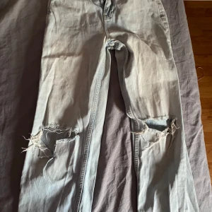 Ljusblå jeans med slitningar - Säljer ett par ljusblå jeans från Gina tricot, Perfect Jeans i storlek 32. Väl Använda men har mer att ge!