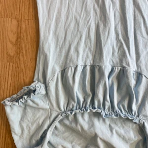 Ljusblå klänning med volangdetaljer - Säljer en söt ljusblå klänning med volangdetaljer. Perfekt för sommardagar eller en avslappnad vårutflykt. Klänningen har en bekväm passform och är tillverkad i ett mjukt material.