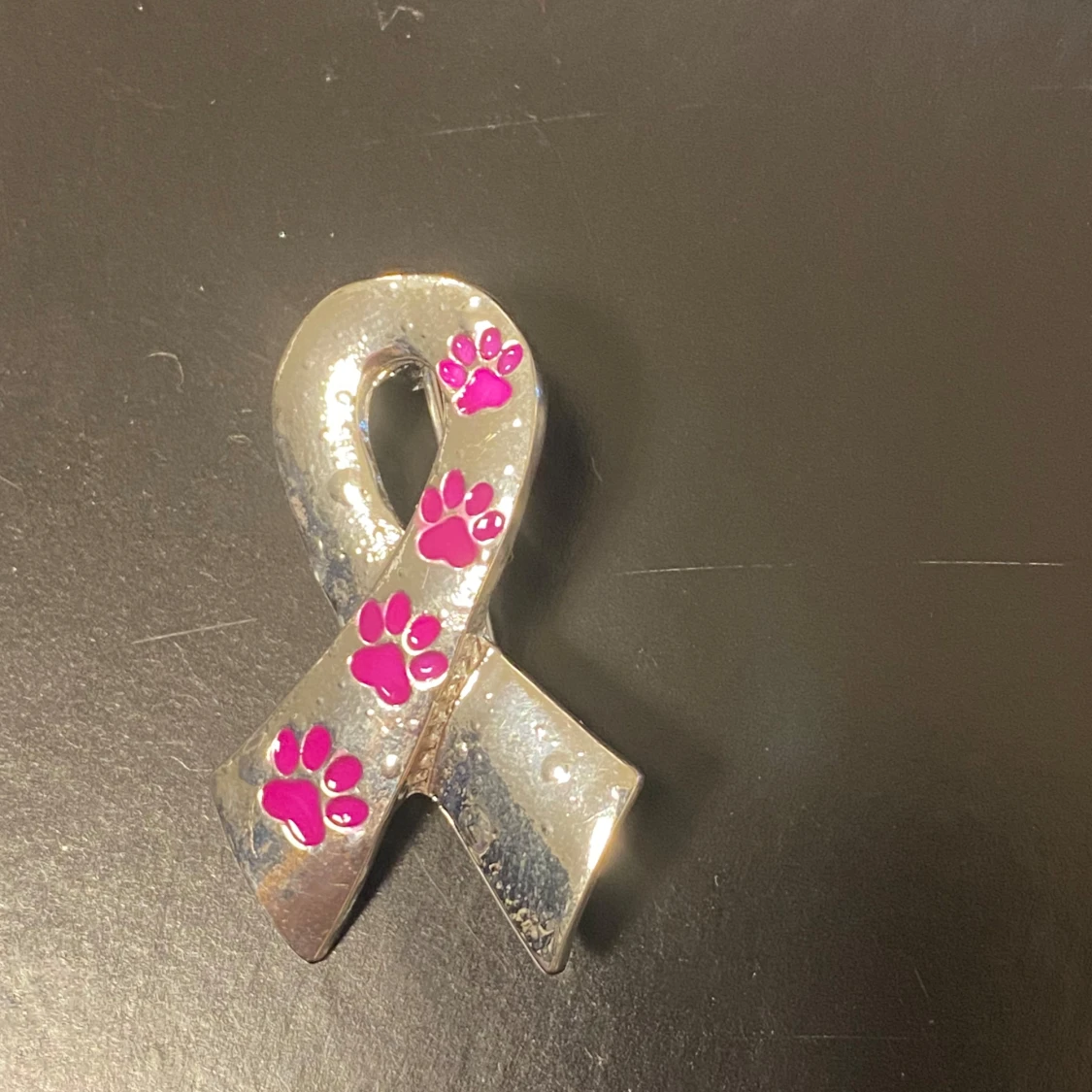 Silvrig brosch med rosa tassavtryck