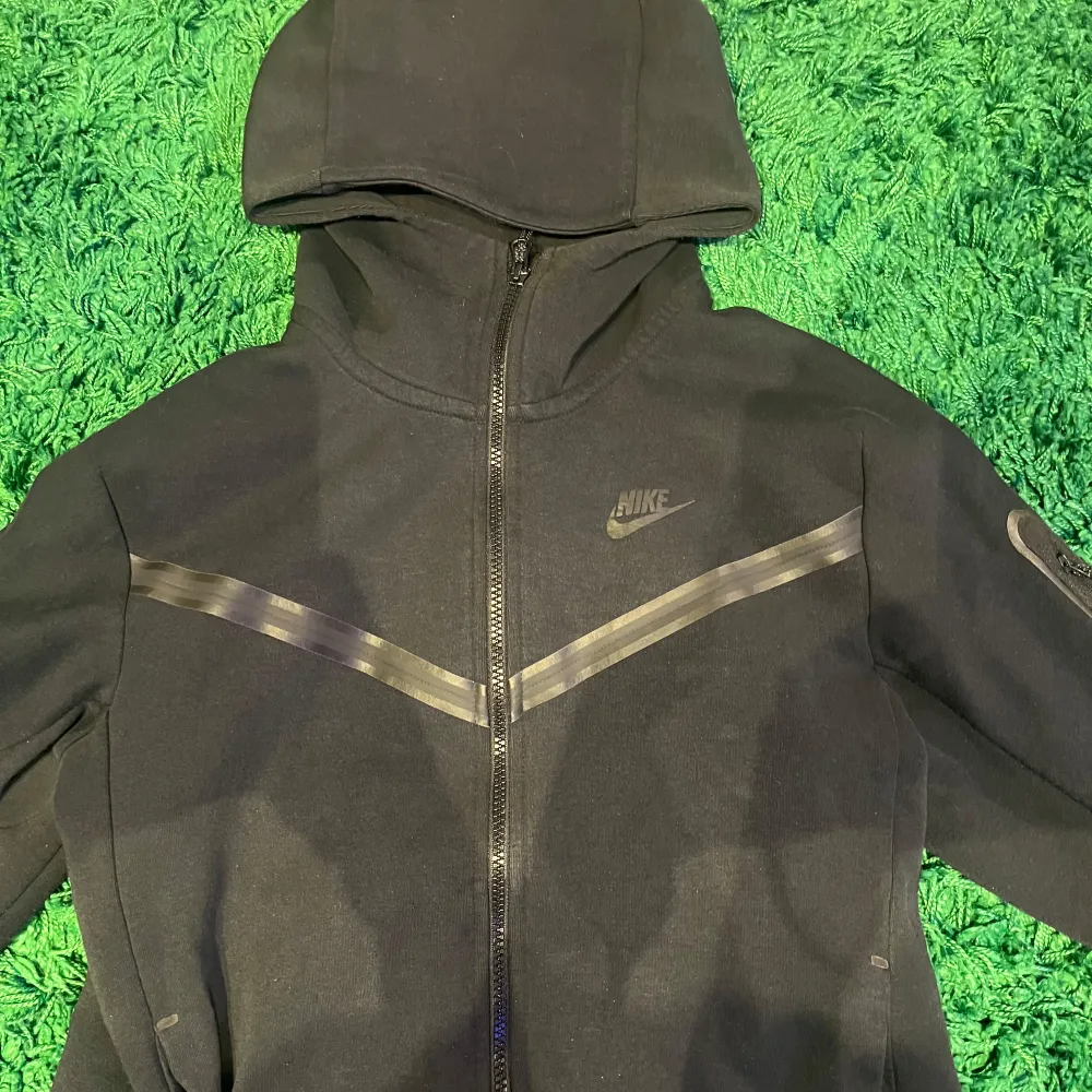 Svart Nike Tech fleece zip i storlek S, det finns en liten reva/hål på högra fickan men inget som märks. . Hoodies.