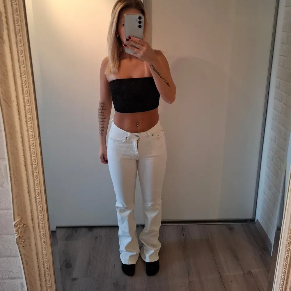 Säljer ett par snygga vita jeans midwaist bootcut. De har en tight passform .Jeansen har en klassisk design med knappar och dragkedja framtill.. Jeans & Byxor.