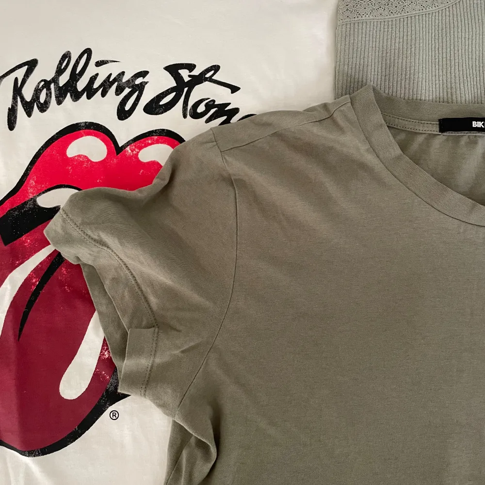 Säljer en samling av olika toppar. Inkluderar en vit t-shirt med Rolling Stones-logga, en olivgrön t-shirt, och flera linnen i olika mönster och färger. Perfekt för sommargarderoben!🫶 30 kr st. Toppar.