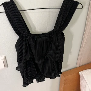 Svart topp från SHEIN  - Säljer en svart blus i bra skick. Den är ärmlös med en fin rynkad fåll. Passar bra till både vardag och fest.🖤 aldrig använd  