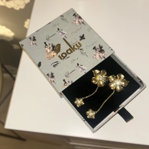 Guldblommiga örhängen med kedja - Supersnygga populära blomörhängen från IOAKU. Passar både till vardags och festliga tillfällen. Man får med original lådan om man vill! Mycket bra skick!🥰 Pris kan diskuteras!