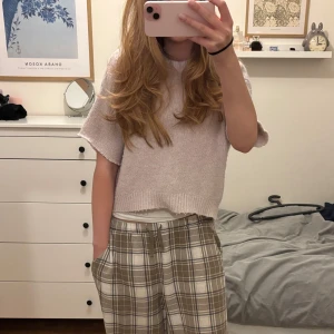 Ljusrosa stickad T-shirt - Superfin ljusrosa stickad tröja från Bershka i storlek S. Den är croppad och har korta ärmar, perfekt för en avslappnad look. Tröjan är mjuk och bekväm, idealisk för både vår och sommar. Passar perfekt till ett par jeans eller kjol för en söt outfit! 🌸