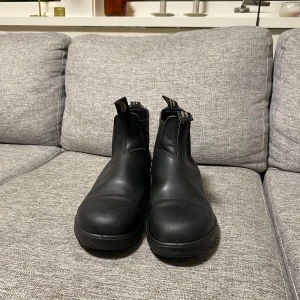 Svarta boots från Blundstone - Säljer ett par klassiska svarta Blundstone boots i skinn. De är i mycket bra skick och perfekta för höst och vinter. Bootsens elastiska sidor gör dem lätta att ta på och av. De har en robust sula som ger bra grepp. Perfekta för både stad och natur!