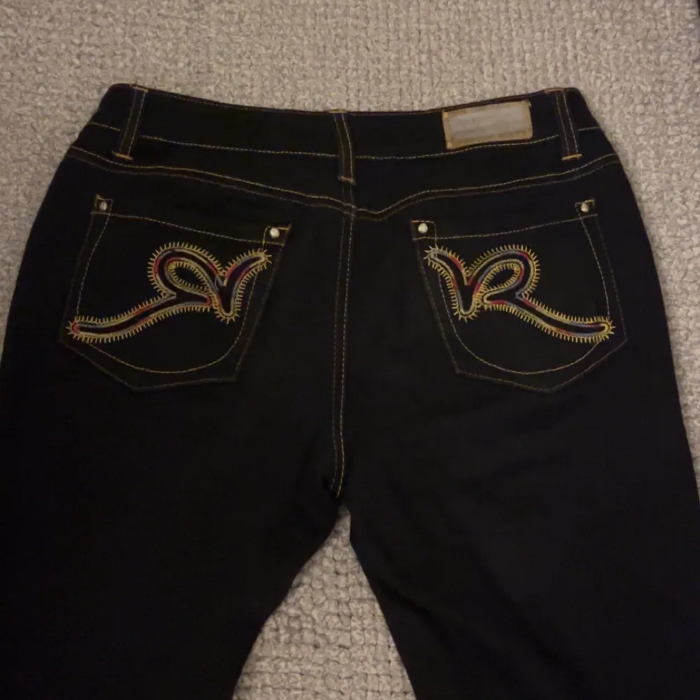 Säljer ett par snygga lågmidaje bootcut svarta jeans från Rocawear med coola broderade detaljer på bakfickorna, då de inte kommer till användning och är lite korta för mig som är 177💕storleken är osäker då det inte står 💕. Jeans & Byxor.