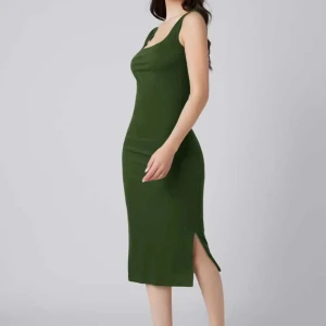 Grön ärmlös klänning - Snygg grön klänning i en  slim passform. Den är ärmlös och har en liten slits på sidan.