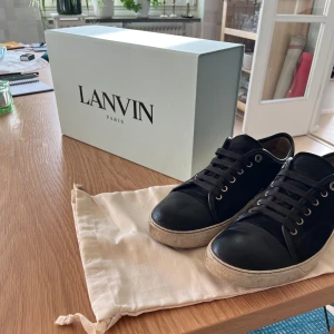 Svarta Lanvin - Svarta lanvin sneakers i storlek 8 ≈(42). Skorna är köpta nya för runt 5 000. Dom är dock riktigt rostiga, men klarar sig nog okej genom nästa sommar. Angående pris lägger jag upp tom för drygt 1000, men är öppen att diskutera.