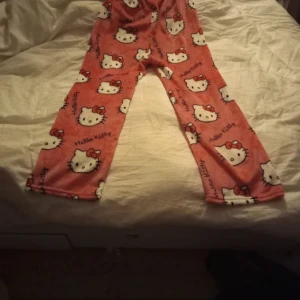 Rosa Hello Kitty byxor - Mysiga rosa byxor med Hello Kitty-motiv. Perfekta för en avslappnad dag hemma. Tillverkade i mjuk polyester för extra komfort. Väldigt små i storleken då det är asiatisk storlek så skulle säga S i vanlig. Endast testade en gång men var då för lite för små för min smak