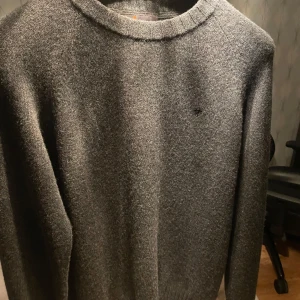 Morris Crewneck - Säljer en stilren grå ulltröja från Morris. Tröjan har en klassisk rund hals och långa ärmar, perfekt för kyligare dagar. Den är mjuk och bekväm och är iprincip i nyskick, använd 3 gånger! Storlek M men passar även L🔥Hör av dig vid funderingar/ Karl