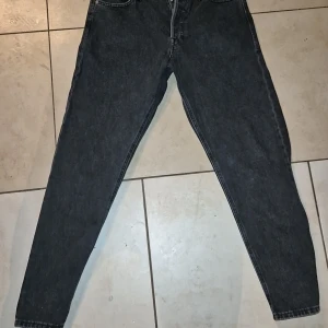 Jack and Jones svarta jeans - Snygga svarta jeansbyxor med en klassisk design. De har en normal passform och är perfekta för en avslappnad stil. Byxorna har fem fickor.