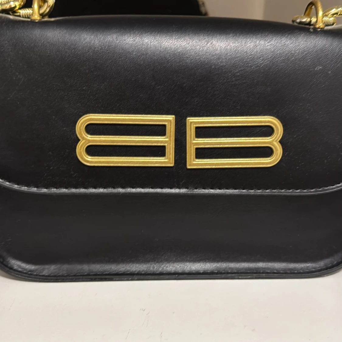 Svart axelväska med gulddetaljer