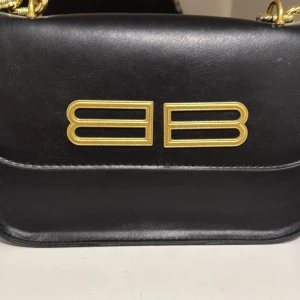 Svart axelväska med gulddetaljer - Jag har den väska jag vill sälja 