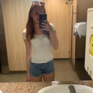 Blå jeansshorts - Snygga blå jeansshorts med en klassisk design. De är korta och har en normal passform, perfekta för varma sommardagar. Shortsen har en enkel stil utan extra detaljer, vilket gör dem lätta att matcha med olika toppar.