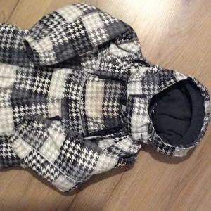 Fin overall Name it ,stl 80 - Säljer en mysig overall med svartvit rutigt mönster. Den har en praktisk huva och elastiska band vid fötterna för extra komfort. Perfekt för kyliga dagar.