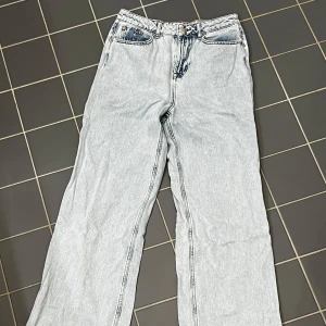 Ljusblå jeans från NA-KD - Säljer ett par ljusblå jeans från NA-KD med en avslappnad passform. Byxorna har en hög midja och vida ben. 