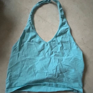 Turkos halterneck linnetopp - Säljer en snygg turkos halterneck linnetopp. Perfekt för varma sommardagar med sin lätta och luftiga design. Toppen har en enkel och stilren look som passar till många olika outfits.