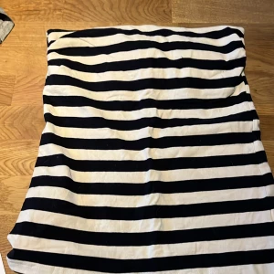 Randig topp från H&M - Säljer en stilren randig topp från H&M i svart och vitt. Toppen har en klassisk design utan ärmar med horisontella ränder och en bekväm passform. Perfekt för en avslappnad look. Den har dubbelt tyg upp till med resårband. Djur finns i hemmet 